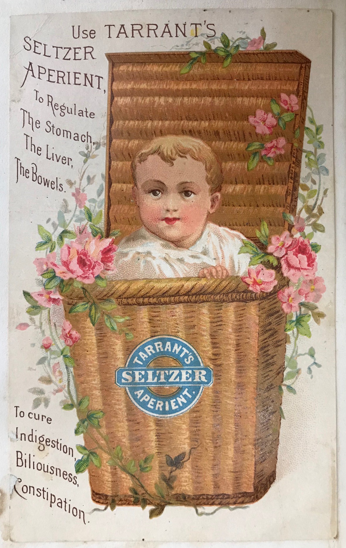 Trade card with a baby in a floral basket advertising Tarrant’s Seltzer Aperient, 1880s